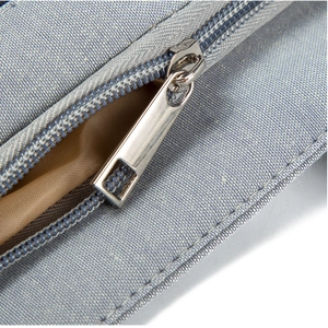Macro shot of silver metal zipper and light grey-blue fabric texture of the nurse tote bag