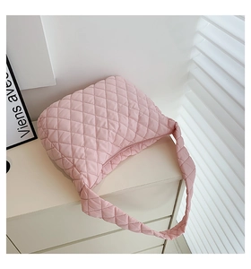 Close-up of pink quilted cloud bag with diamond stitching on a white cabinet