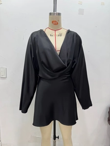 Détail du col drapé élégant et de la texture satinée brillante de la mini robe noire chic