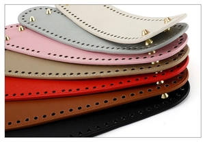 Close-up of colorful PU leather bag bottoms with pre-drilled holes and golden metal studs
