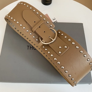 Close-up of wide brown leather belt with silver studs and circular metal buckle