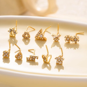 Set of 10 gold-plated nose studs with zircon butterfly and heart shapes on ceramic tray
