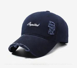 Close-up of distressed navy baseball cap featuring white Capital embroidery and frayed details