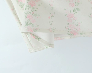 Gros plan du tissu imprimé floral avec des motifs de fleurs roses sur mousseline blanche
