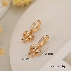 Detailed view of gold bow earrings with cubic zirconia and size dimensions