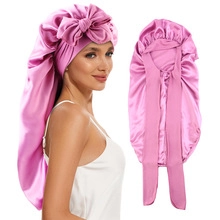 Pink satin hair bonnet with large bow detail and long tail for long hair care