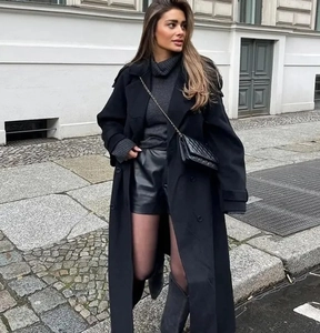 Photo street style d'un long manteau noir en laine à double boutonnage et large revers