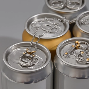 Close-up of bicolor soda tab pendant necklace displayed on metallic beverage cans