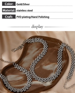 Detail of silver stainless steel woven chain necklace with lobster clasp on silk