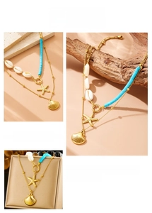 Detail of double-layer gold necklace with starfish, shells and blue beads