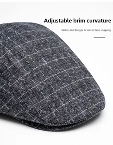 Detail of grey plaid newsboy cap showing the foldable wide brim and woven texture