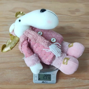 Pink sequin reindeer plush toy decoration on an electronic scale showing product weight 297g