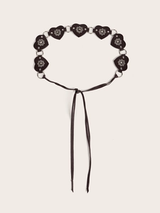 Detail of black leather belt with heart-shaped patches, metal rivets and connecting rings