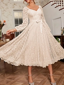 Robe élégante en dentelle blanche évasée avec col en V, manches longues et ceinture