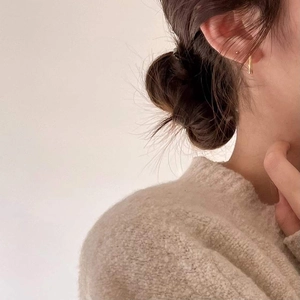 Minimalist 925 sterling silver gold wavy earrings worn by a model in warm lighting