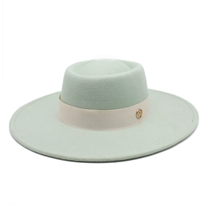 Close-up of mint green wool fedora with beige silk band and gold metal logo buckle