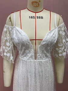 Detailed view of white lace wedding dress featuring floral embroidery and sequins