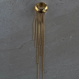 Detailed macro view of gold tassel ear cuff earrings with dangling chain fringe detail