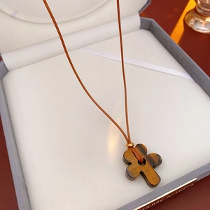 Close-up of tiger eye flower pendant with brown braided cord in a premium jewelry box