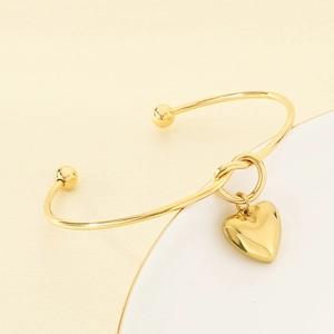 Gros plan du bracelet jonc noué or rose avec un pendentif en forme de cœur poli en C