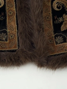 Detail of beaded embroidery on velvet vest with thick brown faux fur trim accents