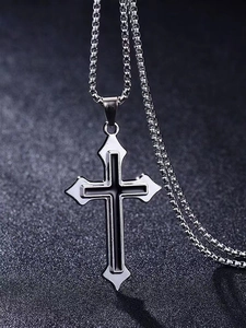Macro detail of silver box chain and dual-layer black and silver cross pendant