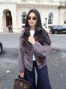 Détail d'une veste violet foncé avec fausse fourrure en V et manches en maille