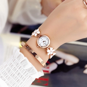 Rose gold five-leaf clover bracelet watch set with white dial on a female wrist