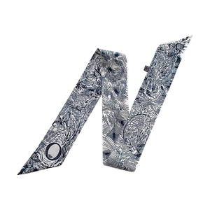 Detail of blue and white silk twilly scarf with elegant hand-painted botanical patterns