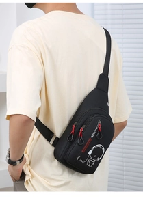 Back view of black crossbody chest bag with astronaut print and red zipper details