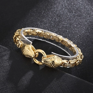 Macro view of gold-plated Byzantine chain bracelet with detailed twin snake head clasp