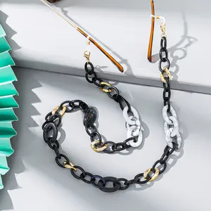 Detail of colorful acrylic eyewear chain with black, white, and gold rings and silicone loops