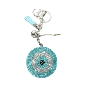 Evil eye rhinestone keychain with light blue crystals and leather tassel on white background