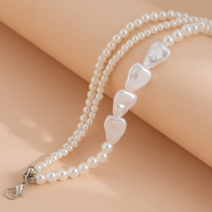 Detail of layered pearl necklace with baroque pearls and silver lobster clasp closure