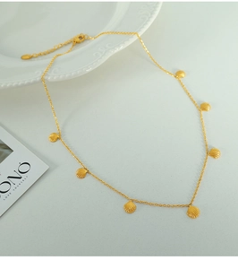 Detailed shot of gold shell pendants on a thin necklace with lobster clasp and chain