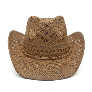 Detail of a brown straw cowboy hat featuring geometric hollow ventilation patterns