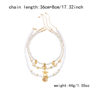 Gros plan du collier multicouche avec perles blanches et pendentifs étoile de mer