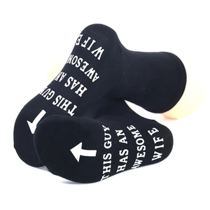 Detail of black cotton socks with white 'THIS GUY HAS AN AWESOME WIFE' print and arrow