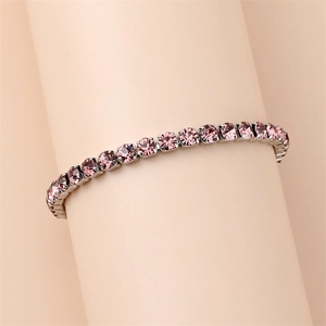 Detail of tennis bracelet with pink round-cut crystals in silver claw setting
