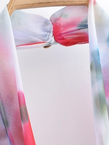Close-up of floral print halter neck midi dress fabric with abstract tie-dye pattern detail