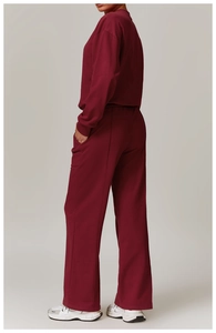 Detail view of burgundy high-waist wide-leg track pants with vertical decorative stitching