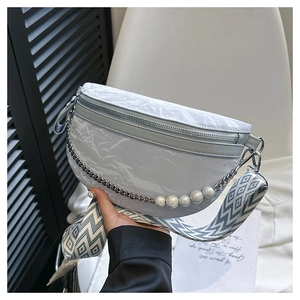 Detail of grey crescent bag with ruched texture, pearl chain and geometric strap