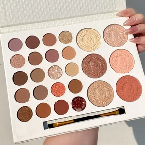 Detail of 26-color eyeshadow palette with shimmer, matte textures and a makeup brush