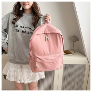 Dettaglio dello zaino in tela rosa con scomparto principale e design casual scolastico