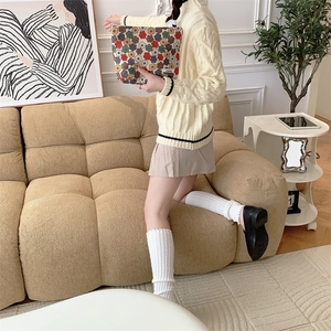 Détail d'une trousse en velours côtelé à fleurs vintage tenue par un mannequin