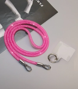 Pink sparkly rhinestone crossbody phone lanyard with silver hooks and magazine backdrop