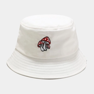Gros plan sur la broderie champignon rouge et blanc sur un chapeau bob en coton blanc