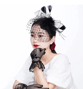Detail of vintage black mesh veil headpiece with feathers and matching lace gloves set