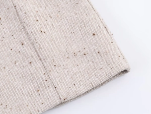 Vue macro détaillée du tissu beige du blazer montrant la texture et le tissage du lin
