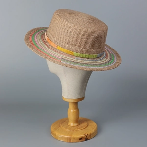 Detailed close-up of handmade boater hat with vibrant rainbow striped brim and woven texture